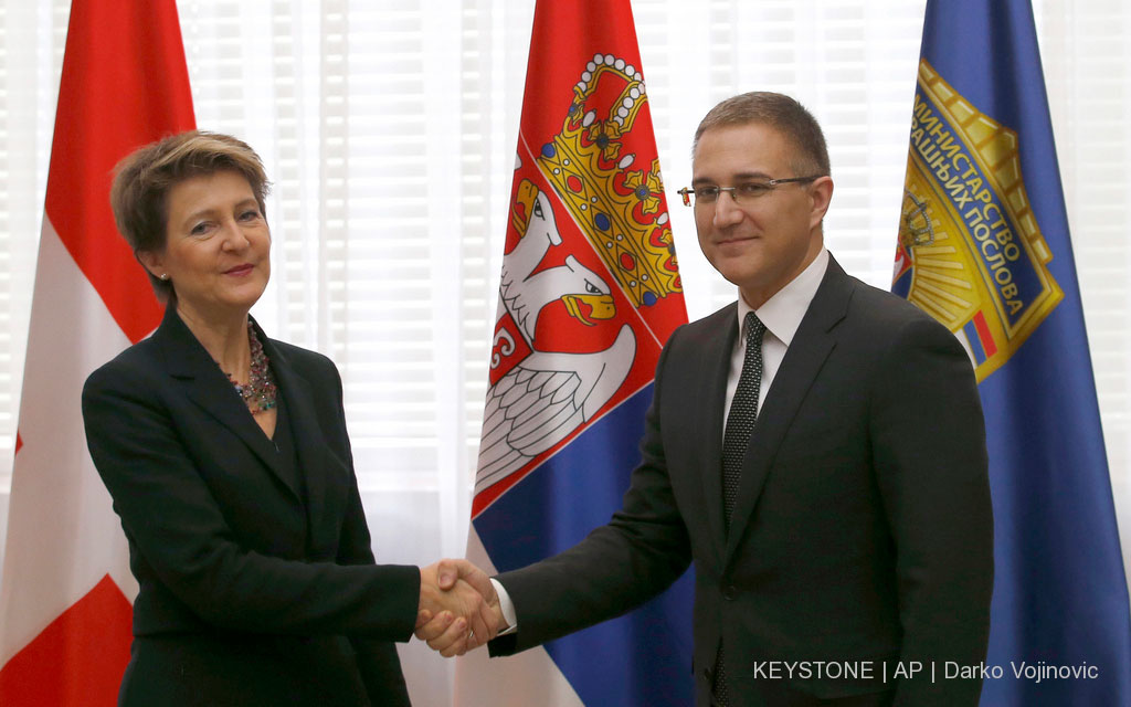 Der serbische Innenminister Nebojša Stefanović (rechts) begrüsst Bundesrätin Simonetta Sommaruga. Im Hintergrund sind die Fahnen der Schweiz und Serbiens zu sehen.