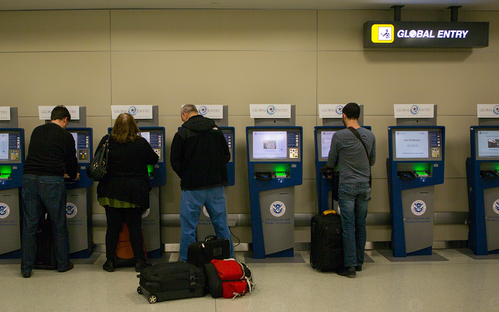 Reisende stehen an Global Entry Automaten an einem internationalen Flughafen